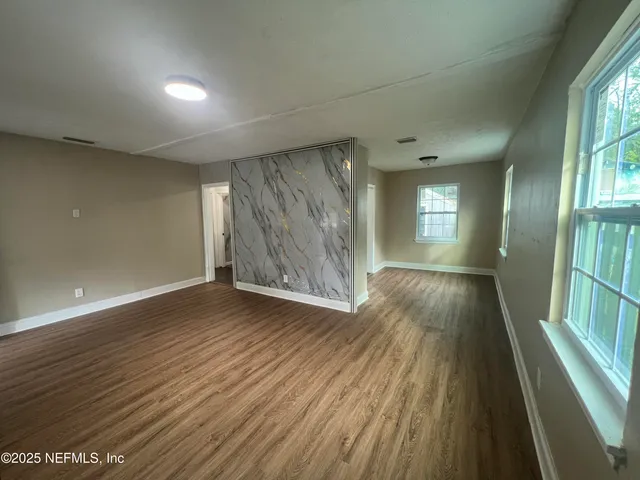 wooden floor in an empty room with a window