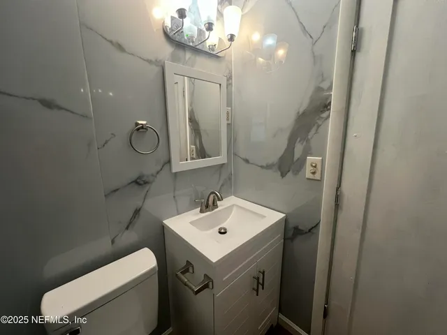 a bathroom with a sink a toilet and mirror