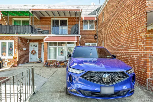 a view of a brick house with a chairs and table in a patio