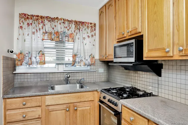a kitchen with granite countertop a sink a stove and cabinets