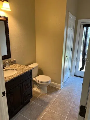 a bathroom with a granite countertop toilet and a sink