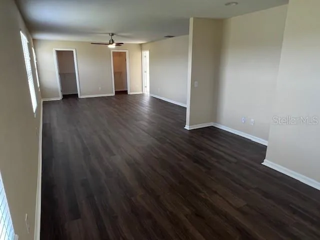 an empty room with wooden floor and window