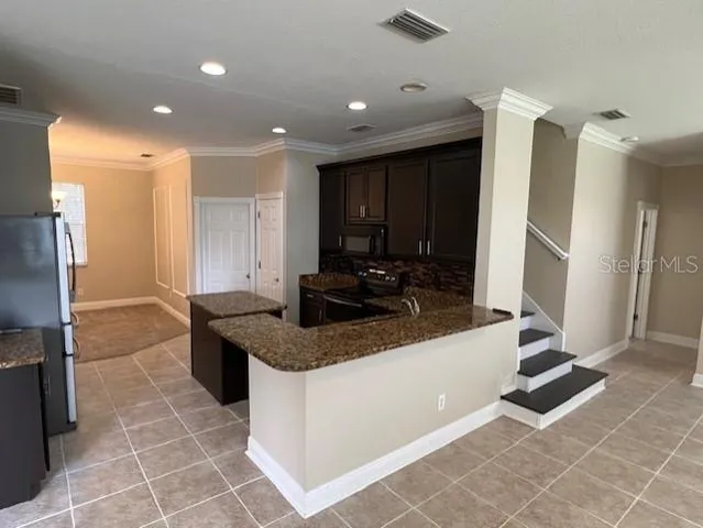 a kitchen with stainless steel appliances granite countertop a sink and a refrigerator