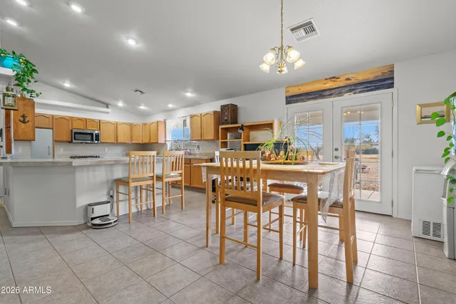a room with stainless steel appliances kitchen island granite countertop a table and chairs