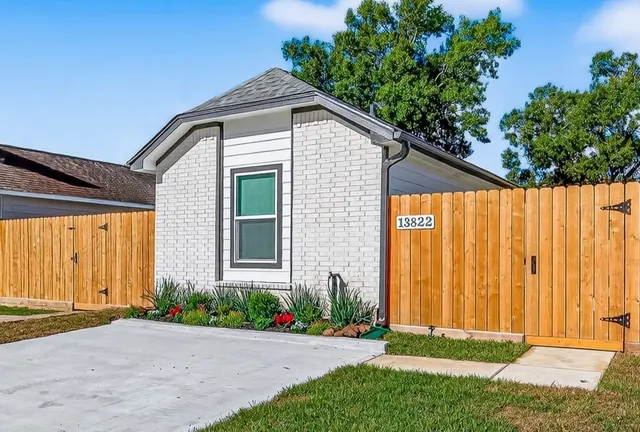 a front view of a house with a yard and potted plants