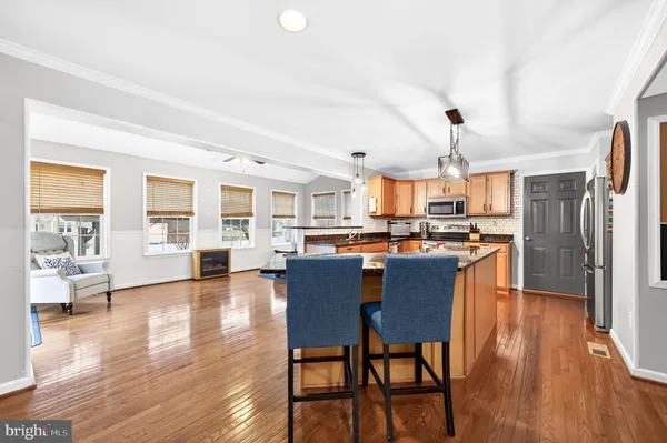 a view of a dining room and livingroom with furniture wooden floor a rug a chandelier