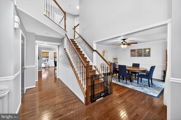 a view of a livingroom with furniture wooden floor stairs and a chandelier