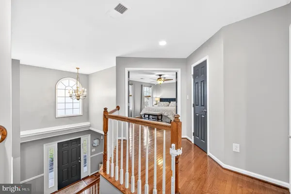 a view of a hallway with wooden floor and a living room
