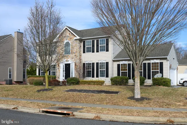 a open kitchen with stainless steel appliances granite countertop a stove top oven a sink a dining table and chairs with wooden floor