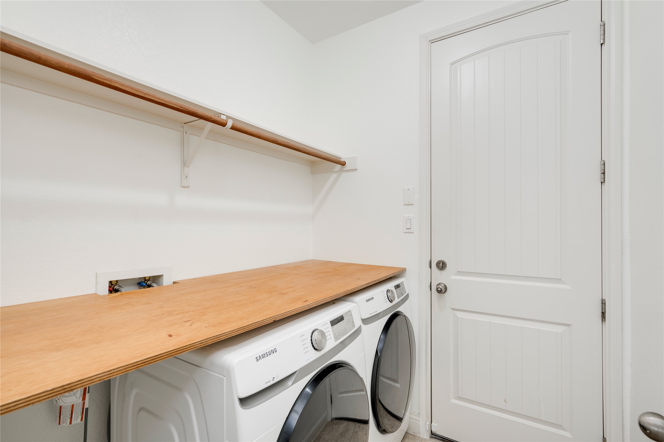 6008 Whipple Way Austin, TX 78745 - Photo 18 of 39 A well-appointed utility room features a convenient hanging rod and practical wood countertop over the washer and dryer.