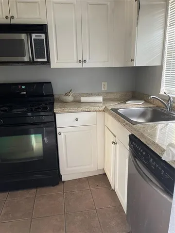 a view of hallway with a large window and stainless steel appliances