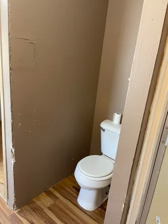 a white toilet sitting next to a small window