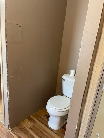 a white toilet sitting next to a small window