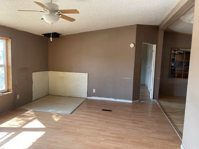 a view of an empty room with closet and a window