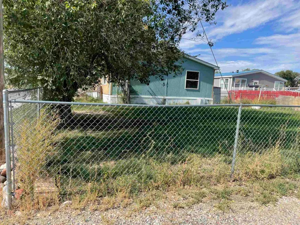a view of a yard with a wooden fence