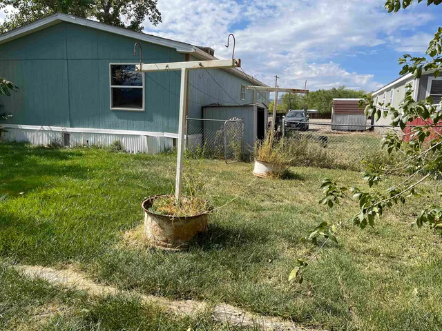 a backyard of a house with fountain table and chairs