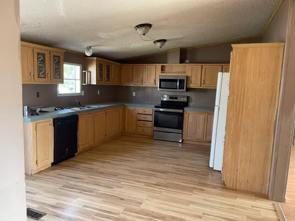 a kitchen with stainless steel appliances granite countertop a stove a sink dishwasher and a refrigerator