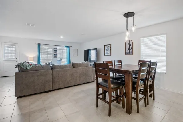 a living room with furniture a dining table and a window