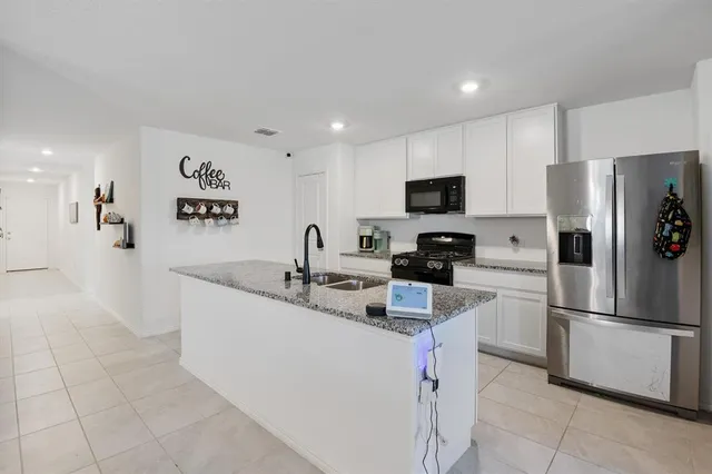 a kitchen with stainless steel appliances granite countertop a refrigerator sink and stove