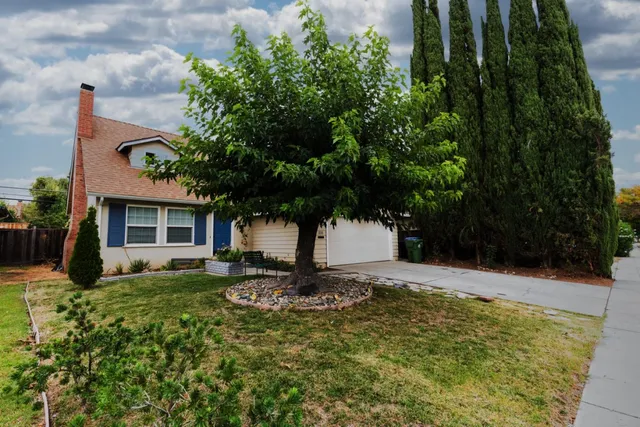 a front view of a house with a yard and trees