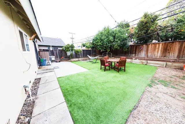 a backyard of a house with table and chairs