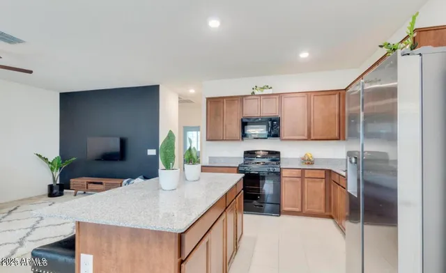a kitchen with stainless steel appliances granite countertop a sink a stove and a refrigerator