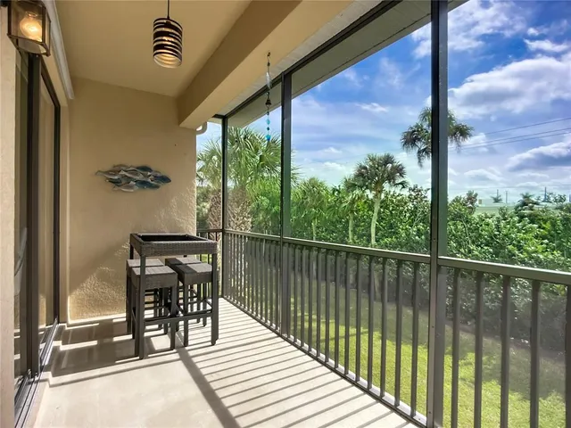 a balcony with wooden floor table and chairs