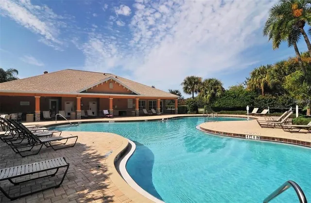 a view of a house with swimming pool and sitting area
