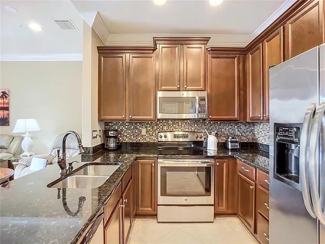 a kitchen with granite countertop a sink stainless steel appliances and cabinets