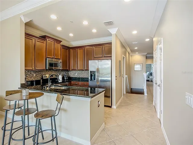 a kitchen with stainless steel appliances granite countertop a refrigerator and a stove top oven