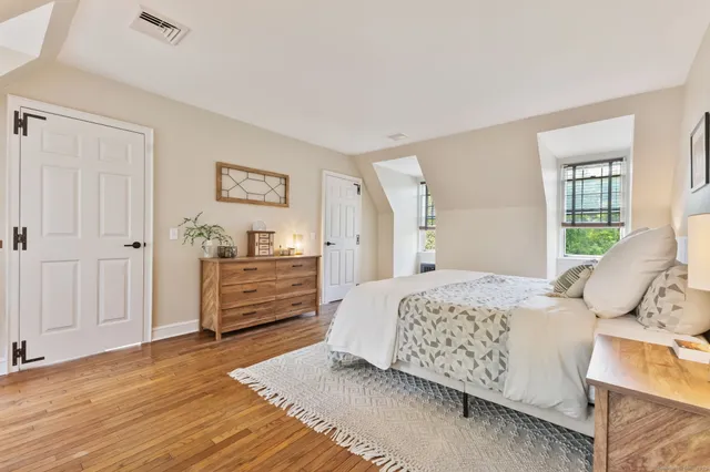 a bedroom with a bed and wooden floor
