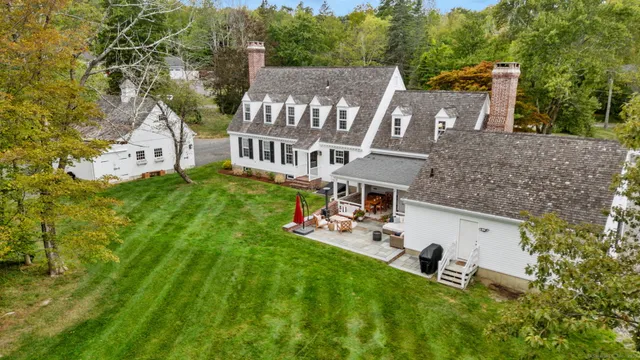 a view of a house with a big yard and large trees