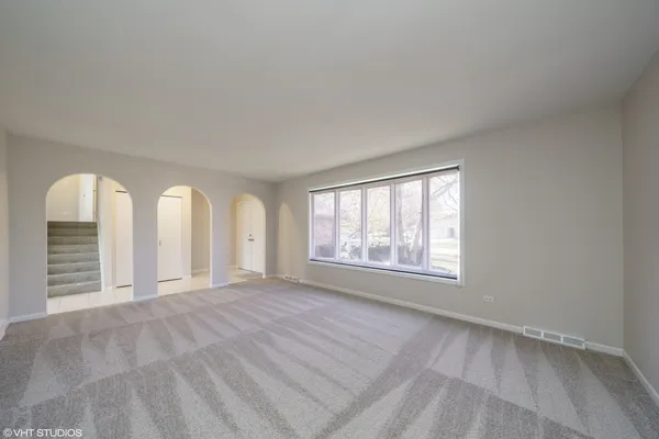 a view of an empty room with a window and closet