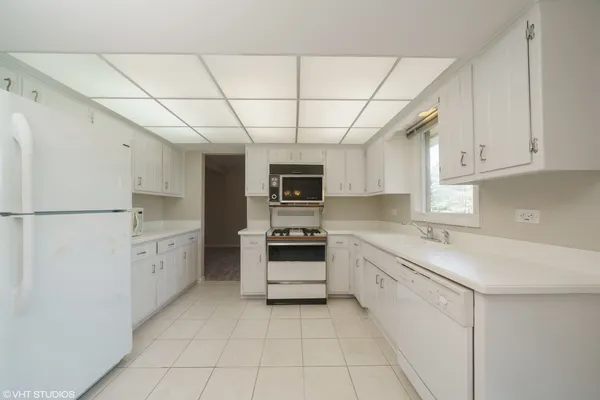 a kitchen with white cabinets and white appliances