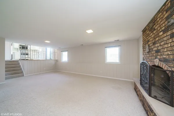 a view of an empty room with a fireplace and a window