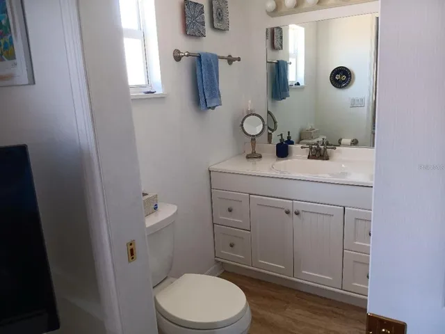 a bathroom with a toilet a sink a mirror and vanity