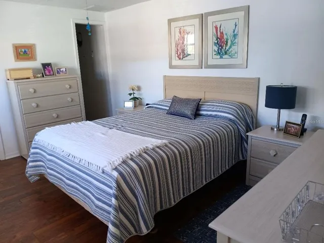 a bedroom with a bed and a computer on the dresser