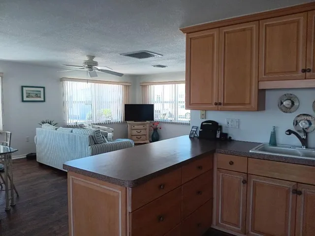 a kitchen with a sink dishwasher stove and microwave with wooden floor