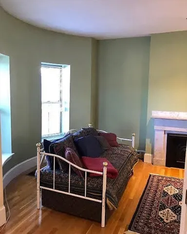 a bed sitting in a bedroom next to a window