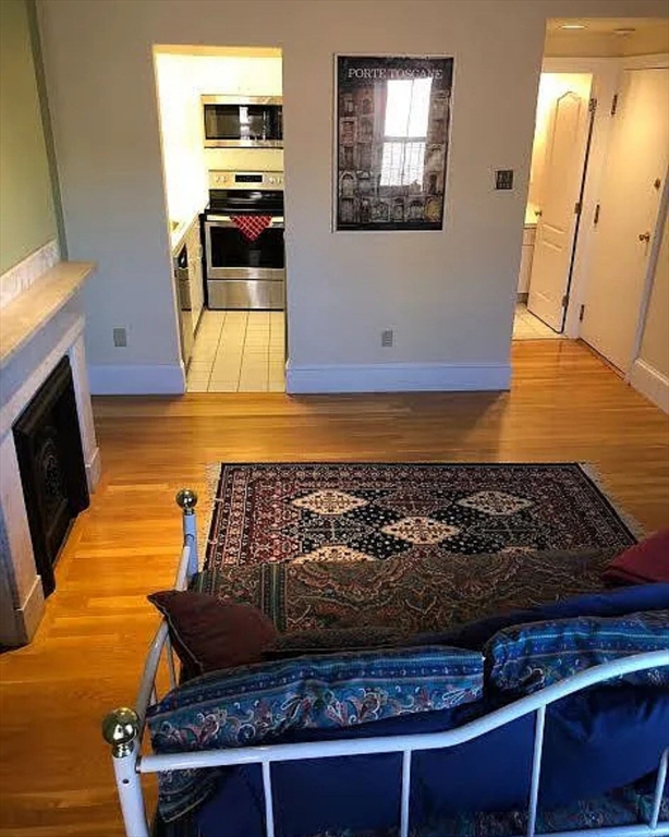 533 Columbus Avenue, Unit 8 Boston, MA 02118 - Photo 4 of 21 a kitchen with kitchen island granite countertop a stove and a wooden floor