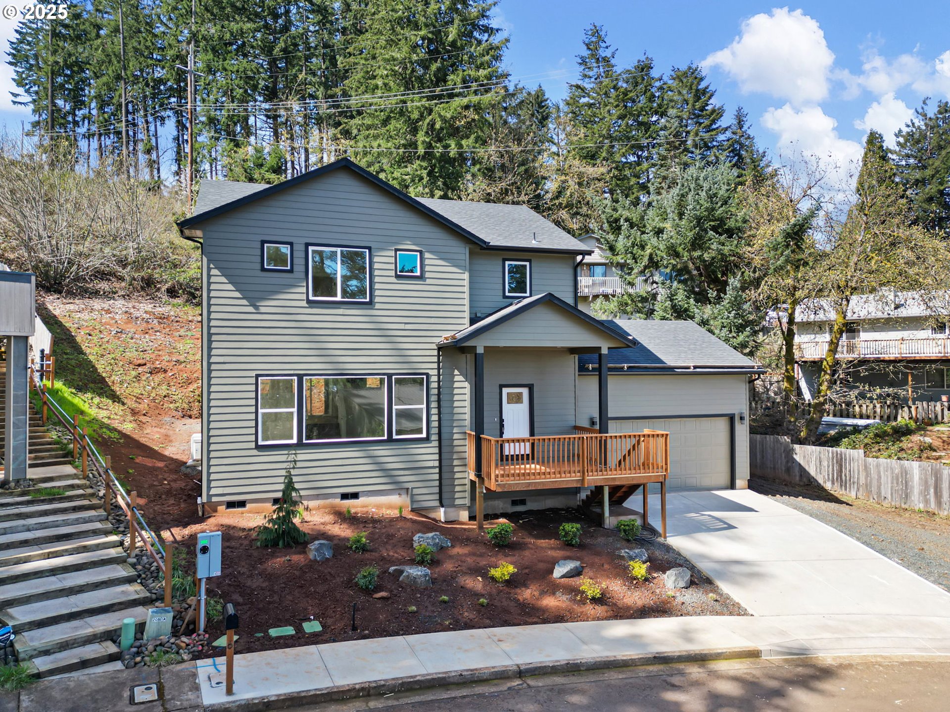 a front view of a house with yard and trees in the background