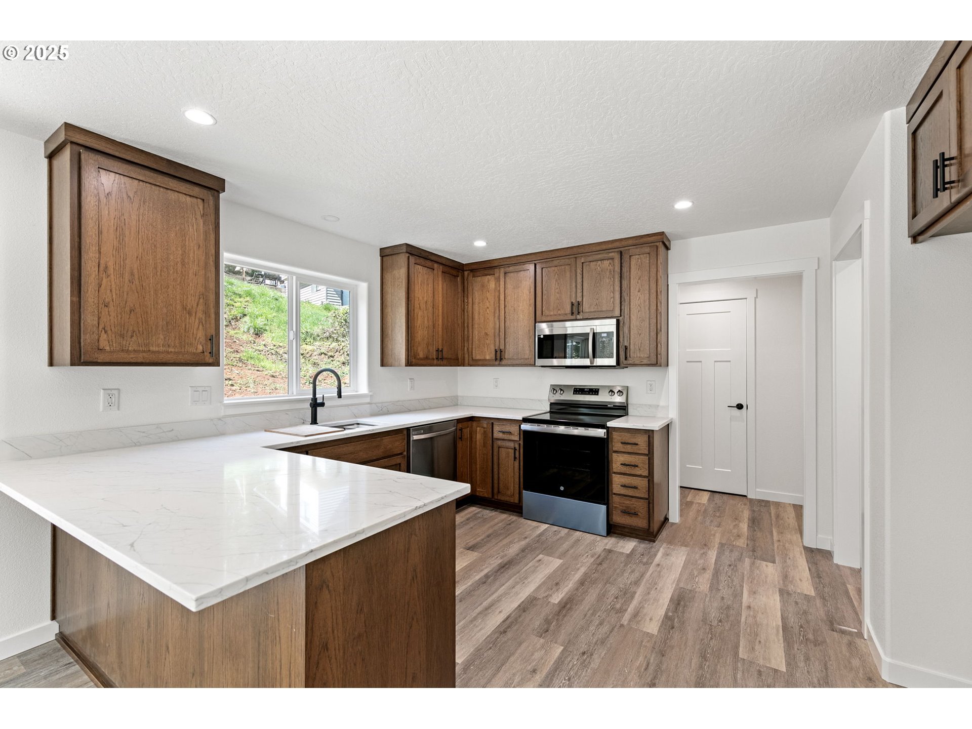 65 Bangle Court Cottage Grove, OR 97424 - Photo 12 of 44 a kitchen with a sink a stove a refrigerator a center island and a window
