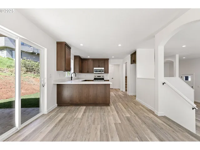 a large kitchen with kitchen island a large counter space a sink appliances and cabinets