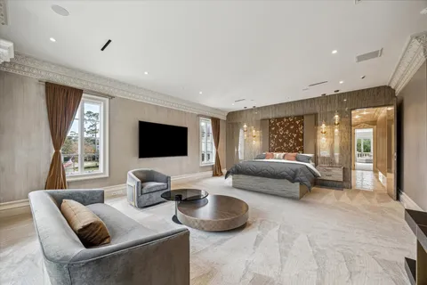 a spacious bedroom with a bed and large flat screen tv