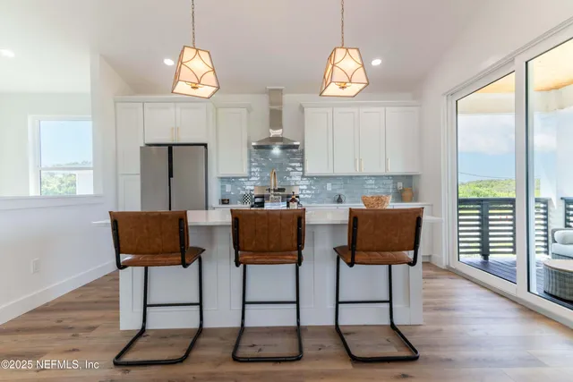 a view of a dining room with furniture a chandelier and wooden floor