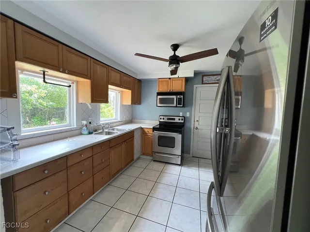 a kitchen with stainless steel appliances a refrigerator sink and microwave