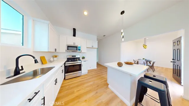 a kitchen with stainless steel appliances kitchen island a white stove top oven and sink