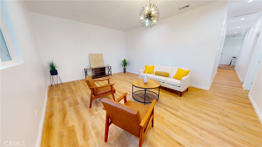 411 West Plum Street Compton, CA 90222 - Photo 3 of 14 a bedroom with a bed and wooden floor