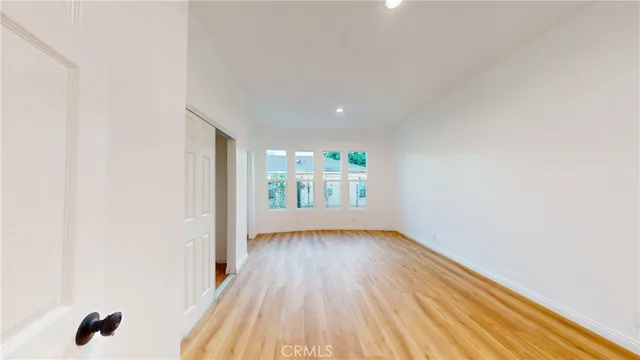 a view of an empty room with wooden floor