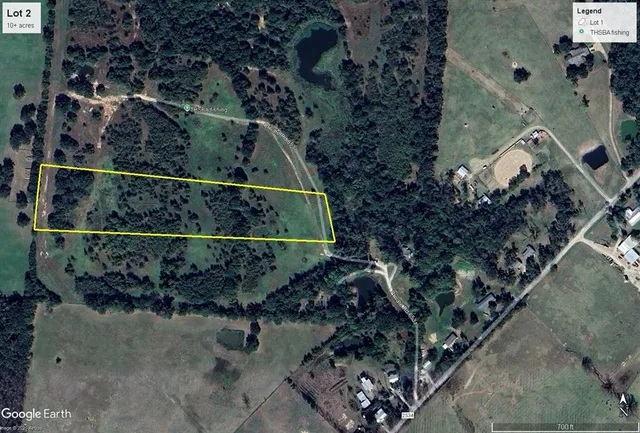 a view of a yard with wooden fence